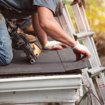 roofers installing new roof on house roofers installing a new roof on residential home. weatherlock material and brown asphalt roofing shingles